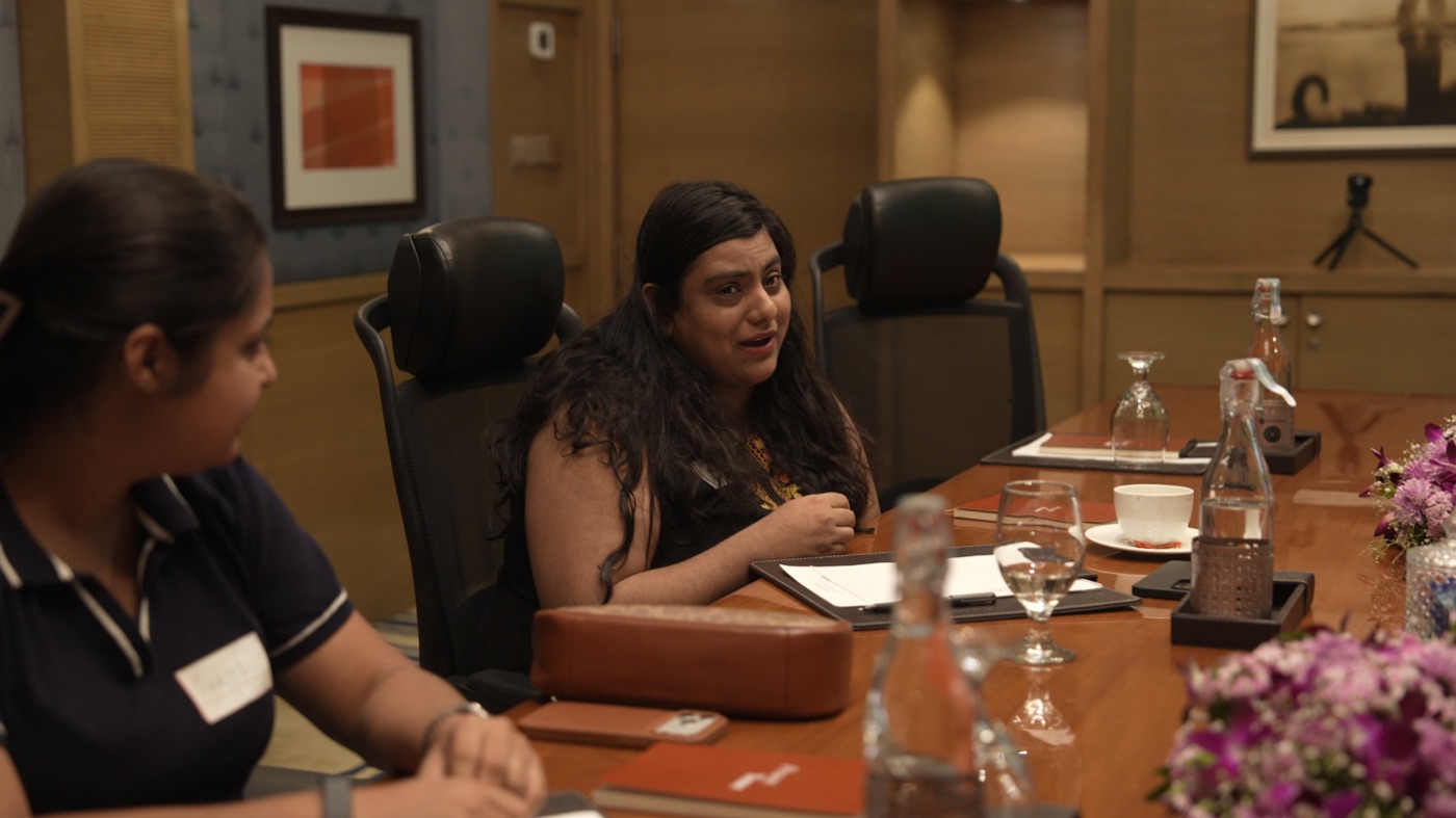 A participant speaking at the table while another listens.