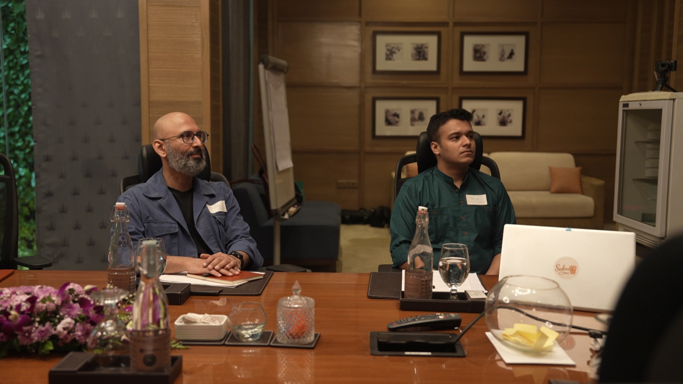 Two participants seated, listening.