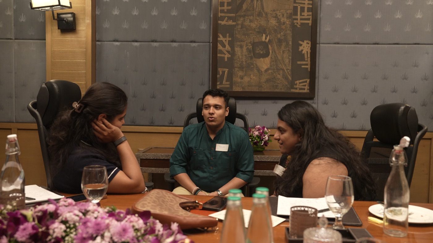 Three participants in close conversation around the table.