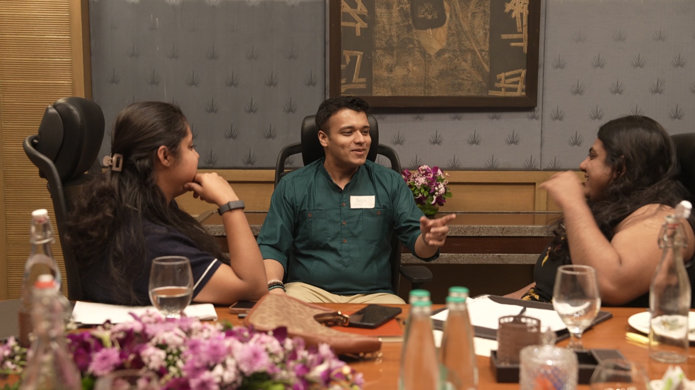 Three participants seated together, one telling a story.