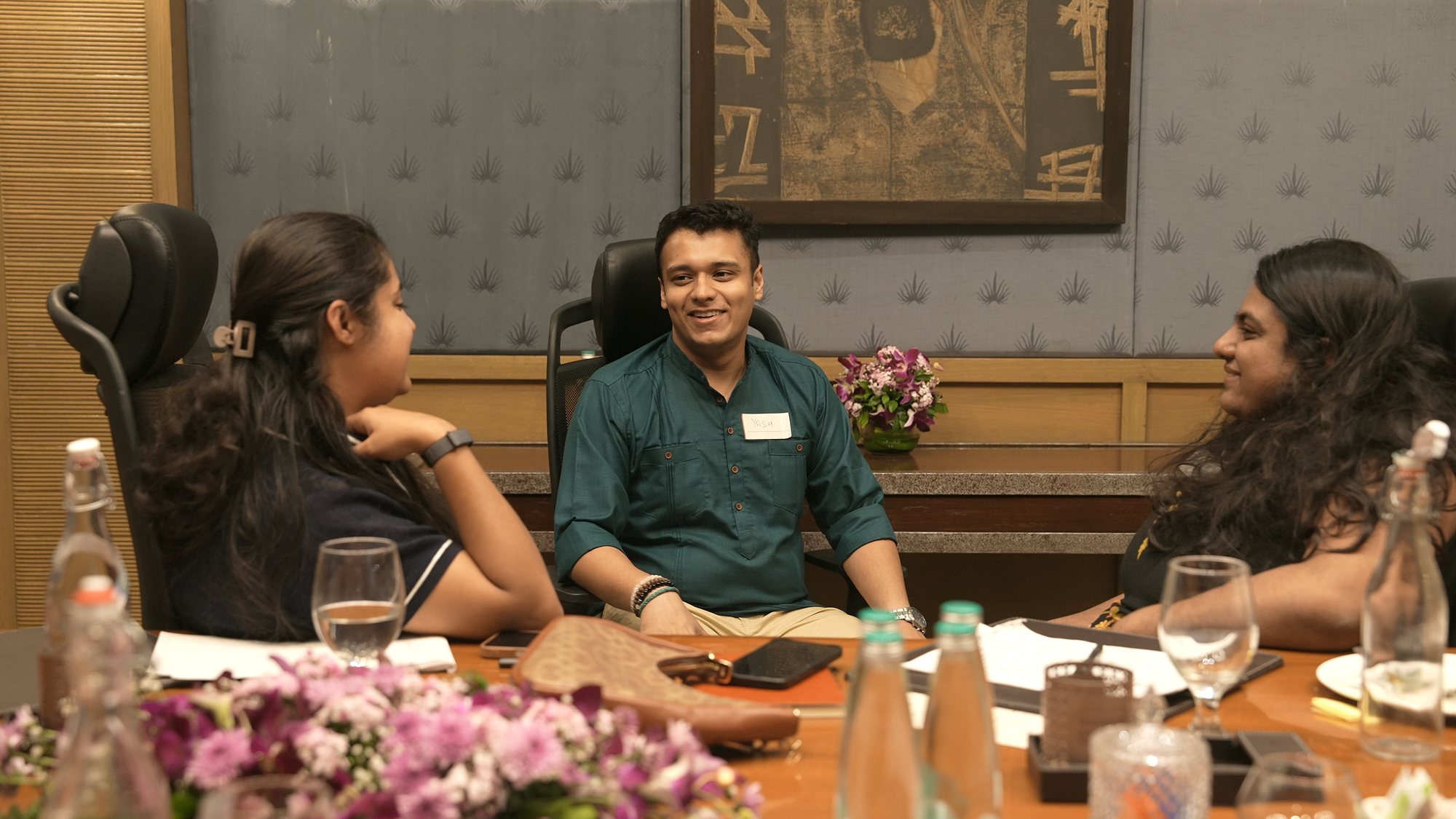 Yash laughing with two participants at the table.